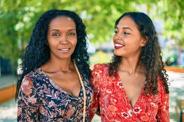 Sticker - African american mother and daughter smiling happy hugging at the park.