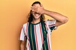 © Krakenimages.com - Young handsome man with long hair wearing casual clothes smiling and laughing with hand on face covering eyes for surprise. blind concept.