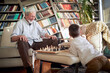 © luckybusiness - Grandpa and his little grandson having a good time while playing the chess game at home. Family, game, together