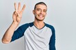 © Krakenimages.com - Hispanic young man wearing casual clothes showing and pointing up with fingers number three while smiling confident and happy.