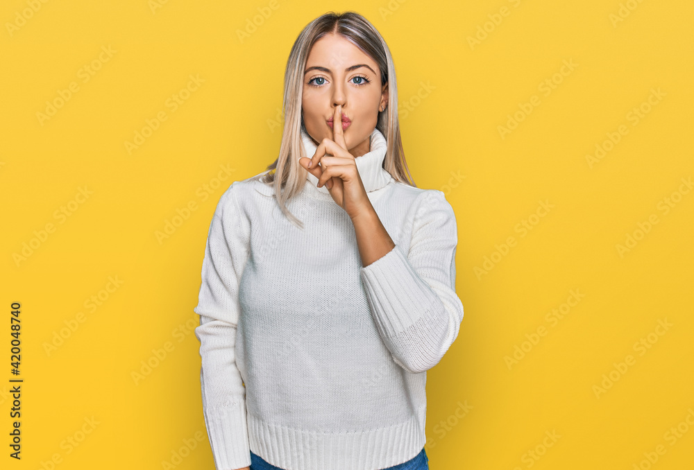 Beautiful blonde woman wearing casual turtleneck sweater asking to be quiet with finger on lips. silence and secret concept. - obrazy, fototapety, plakaty 