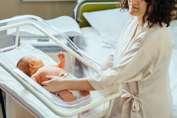 new born baby in maternity hospital. selective focus. mother touching and caressing her infant boy i