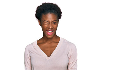 Poster - Young african american girl wearing casual clothes winking looking at the camera with sexy expression, cheerful and happy face.