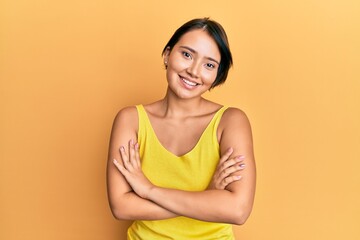 Beautiful young woman with short hair wearing casual clothes happy face smiling with crossed arms looking at the camera. positive person.