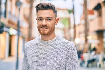 Young caucasian man smiling happy standing at the city.