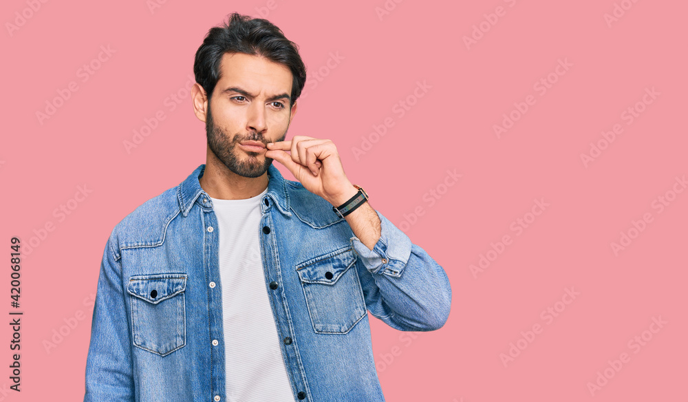 Young hispanic man wearing casual clothes mouth and lips shut as zip with fingers. secret and silent, taboo talking