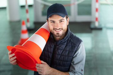 workman holding a traffic cone