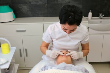 Wall Mural - Preparing the face of a female patient for a cosmetic procedure