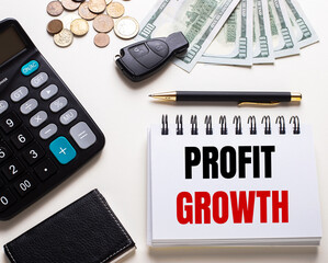 Fototapete - On a white table is a calculator, car key, cash, a pen and a notebook with the inscription PROFIT GROWTH