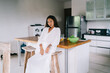 © BullRun - Sensual lady sitting on bar stool in kitchen