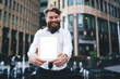 © BullRun - Happy bearded man showing tablet screen