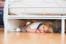 Little Toddler Child, Hiding Under The Bed With Stuffed Toys, Scared
