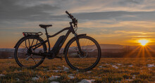 Black And Gray Electric Bicycle In Sunrise Morning Time On Frosty Field