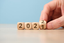 Concept Of Changing The Year From 2021 To 2022 On Wooden Cubes By Hand.