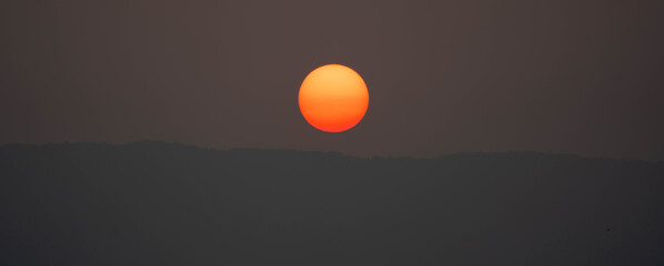 Wall Mural - sunset on sky dark background, big sun golden color on dusk twilight evening wallpaper, beautiful ab
