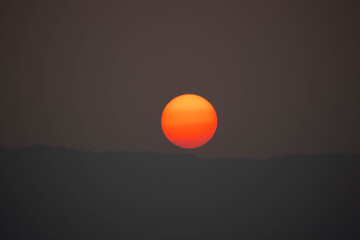 Wall Mural - big red sun down on dark background