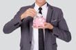 Young asian businessman in suit deposit money dollar with piggy bank isolated on white background, business man saving with planning budget and finance for success investment and financial.