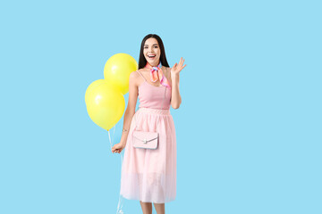 Poster - Beautiful young woman with balloons on color background