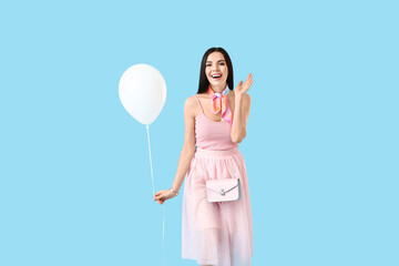 Poster - Beautiful young woman with balloon on color background