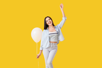 Wall Mural - Beautiful young woman with balloon on color background