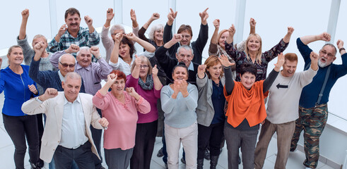 group of mature friends raised their hands up and celebrate succ