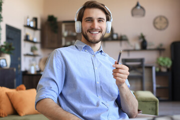 Sticker - Happy young man in earphones working from home during self isolation.