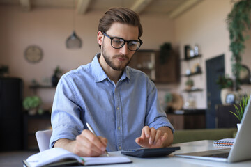 Sticker - Happy young business man is analizing financial documents from home during self isolation.