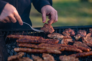 grilled meat cooked and smoked. hands turning the steak on the grill