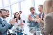 © ASDF - group of business people applauding sitting at the negotiating table
