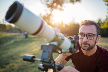 Wall Mural - amateur astronomer looking at the sky with a telescope.