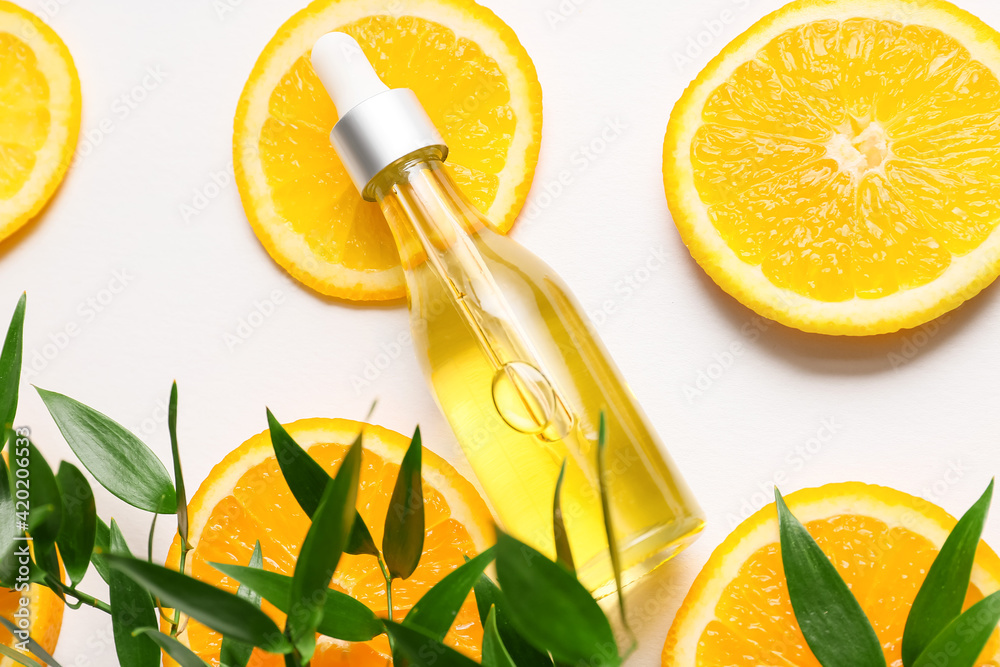 Bottle of orange essential oil on light background