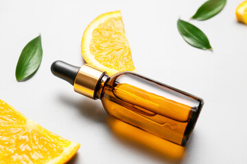 Bottle of orange essential oil on light background