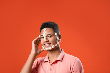 Sticker - Portrait of handsome young man with flowers on face against color background