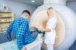 © romaset - Radiologist prepares the patient for an MRI knee examination