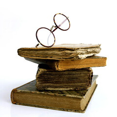 Wall Mural - Stack of old books and glasses isolated on a white background