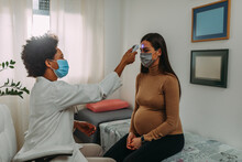 Doctor with a pregnant woman wearing medical masks during an examinations