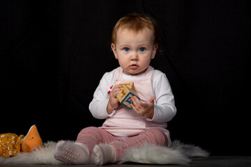 Little beautiful one-year-old girl is played with toys