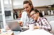 © Dusko - Happy mother with her young daughter enjoying in online shopping or working from home. Business from distance and virtual communication with family and friends.
