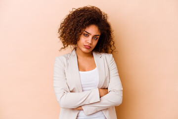 Wall Mural - Young african american woman isolated on beige background who is bored, fatigued and need a relax day.