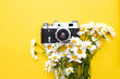 retro camera and a bouquet of flowers on a yellow background