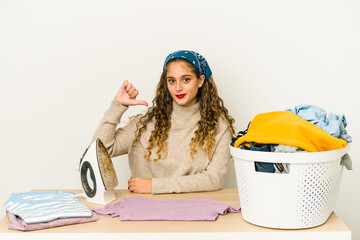 Wall Mural - Young caucasian woman ironing clothes isolated showing a dislike gesture, thumbs down. Disagreement concept.