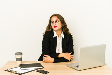 Wall Mural - Young caucasian business woman working on her desktop isolated dreaming of achieving goals and purposes