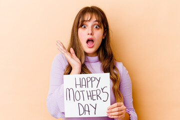 Wall Mural - Young caucasian woman holding a Happy mothers day placard isolated surprised and shocked.