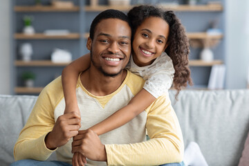 Wall Mural - Closeup portrait of happy black father and daughter embracing