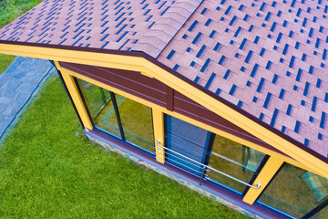 Wall Mural - Tree cottage top view. House with pitched roof and panoramic windows. Roof of house is covered with metal tiles. Cottage is equipped with frame glazing. Scandinavian style cottage concept