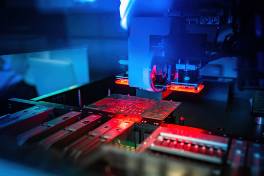 Process of creating a printed circuit board. Machine for production of PCB. Manufacturing of printed circuit boards. PCB board in a laser machine. Concept - testing printed circuit boards with laser
