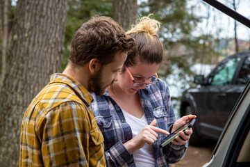 travelers consulting gps and guide on a smart phone outdoors at the cottage