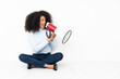 © luismolinero - Young african american woman sitting on the floor shouting through a megaphone