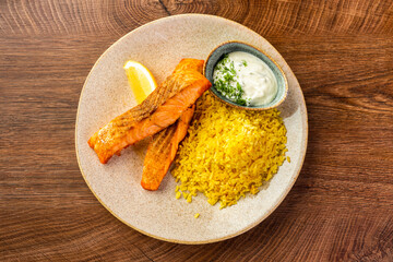 Wall Mural - Fried red fish, curry rice and white sauce on a large plate 