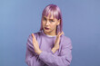 © kohanova1991 - Pretty woman disapproving with NO crossing hands sign gesture. Denying, rejecting, disagree, portrait of beautiful girl with dyed purple hair on violet background